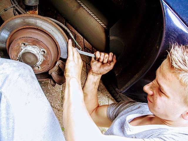 man applying brake pad grease