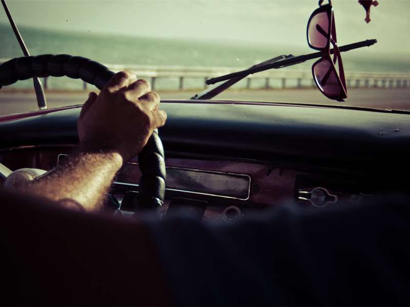 Man holding a vehicle steering wheel