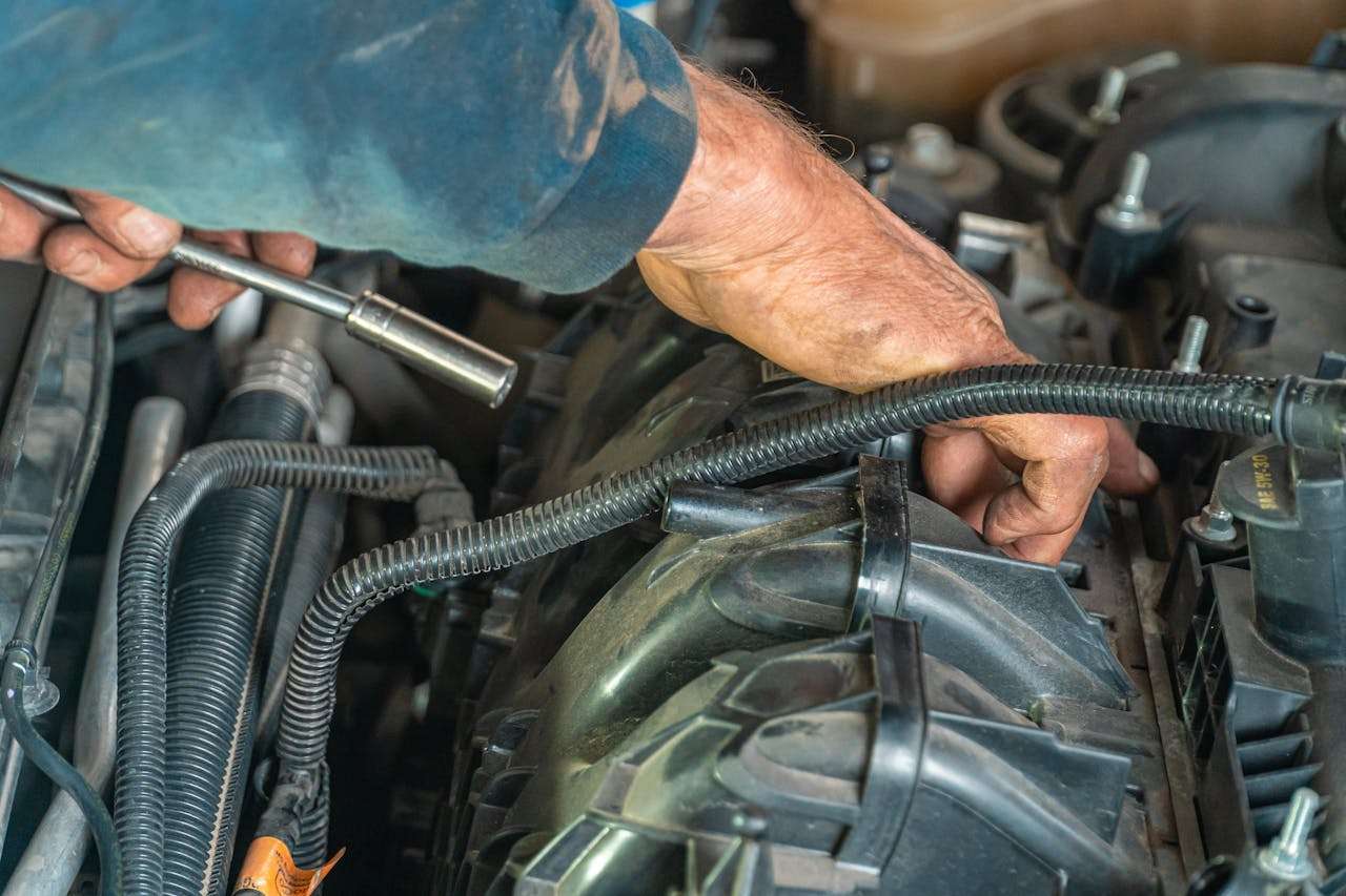 Mechanic working on a car engine spark plug